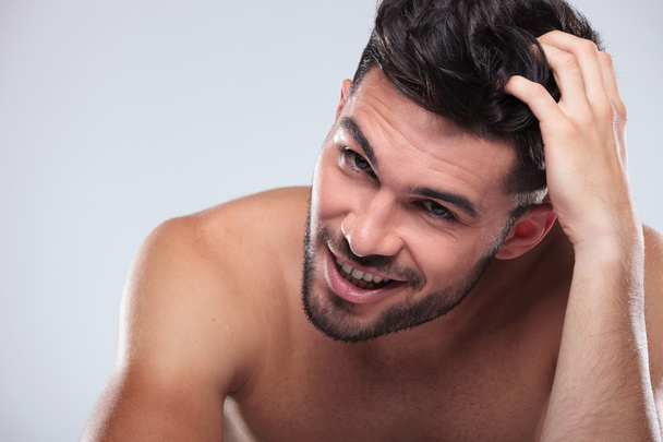 šťastný nahý muž poškrábání hlavu a úsměvy  - Fotografie, Obrázek
