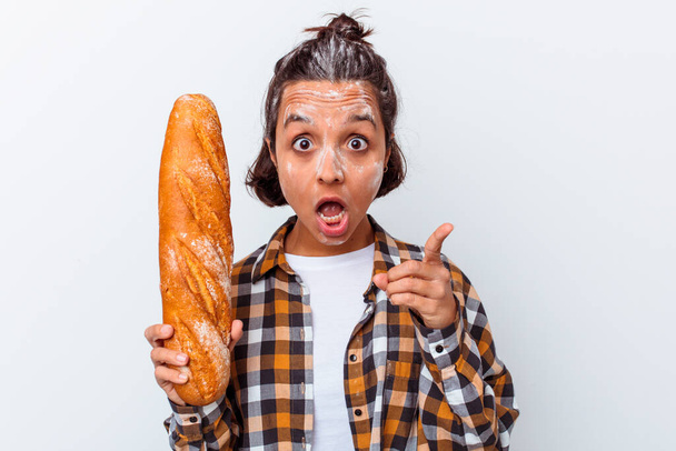 Young mixed race woman making bread isolated on white background having an idea, inspiration concept. - Photo, Image