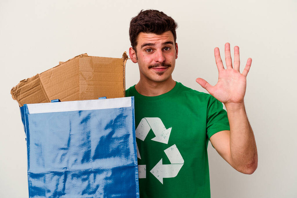 Fiatal fehér férfi újrahasznosítás karton elszigetelt fehér alapon - Fotó, kép
