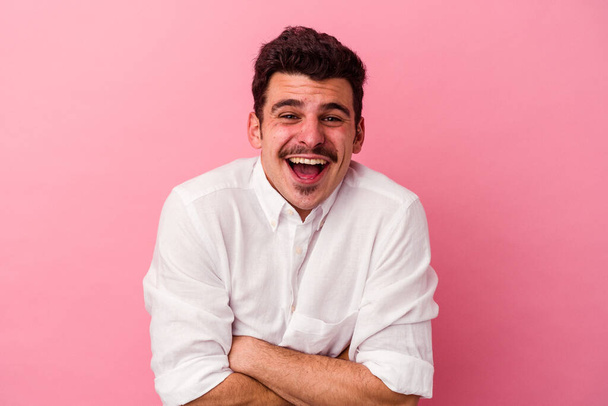 Young caucasian man isolated on pink background laughing and having fun. - Photo, Image
