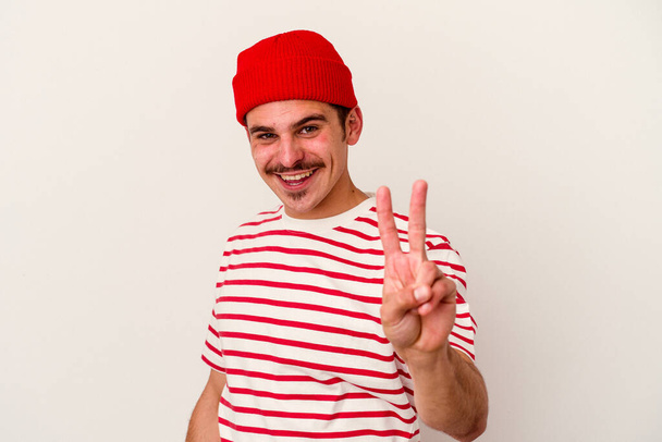 Jeune homme caucasien isolé sur fond blanc montrant le numéro deux avec les doigts. - Photo, image
