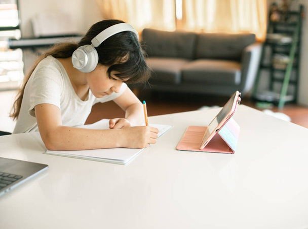 portrét rozkošného bělošského děvčete, jak se učí on-line pomocí notebooku, domácí výuky, vzdáleného vzdělávání - Fotografie, Obrázek