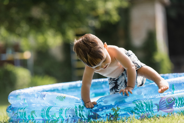 batole chlapec lezení přes nafukovací bazén - Fotografie, Obrázek