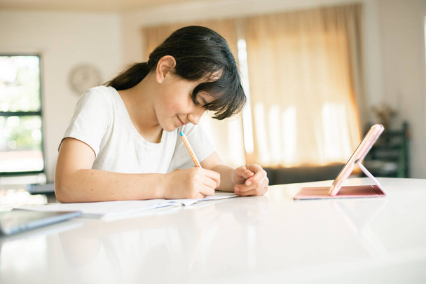 πορτρέτο αξιολάτρευτο καυκάσιο κορίτσι κάνει on-line μάθηση χρησιμοποιώντας φορητό υπολογιστή, κατ 'οίκον εκπαίδευση, μακρινή εκπαίδευση - Φωτογραφία, εικόνα