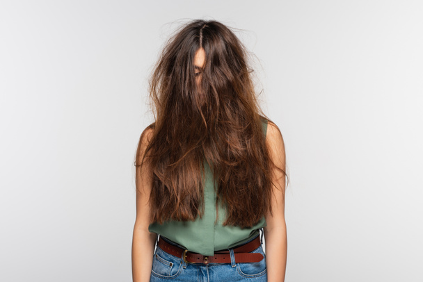 молодая женщина с запутанными длинными волосами изолирована от серого  - Фото, изображение