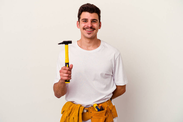 Young caucasian worker man with tools isolated on white background happy, smiling and cheerful. - Photo, Image