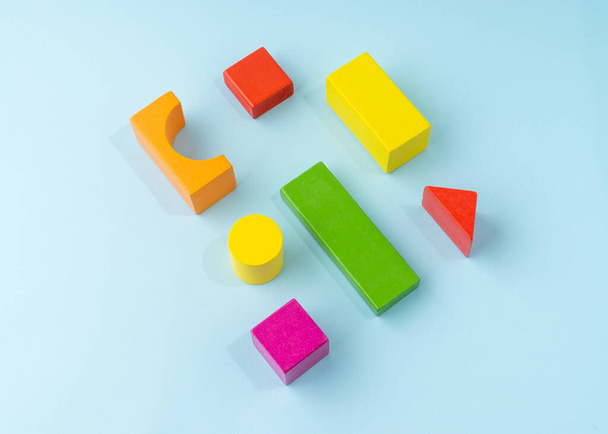 Colorful wooden block toy on light blue background. - Photo, Image