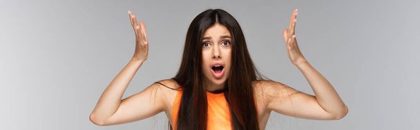 shocked woman with long hair gesturing isolated on grey, banner - Foto, immagini