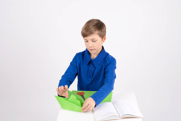 оригами: Мальчик восхищается своей работой, закончил - бумажными поделками - Фото, изображение