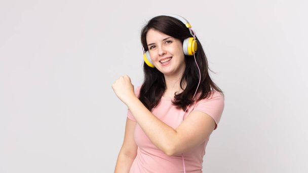 pretty woman feeling happy and facing a challenge or celebrating listening music with headphones - Φωτογραφία, εικόνα