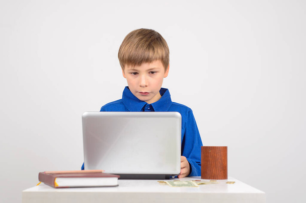 jovem empresário Jovem garoto inteligente procurando netbook ao lado da mesa um caderno de negócios, e dinheiro - Foto, Imagem