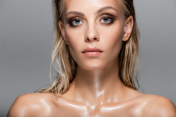 blonde woman with wet body and hair looking at camera isolated on grey - Foto, afbeelding