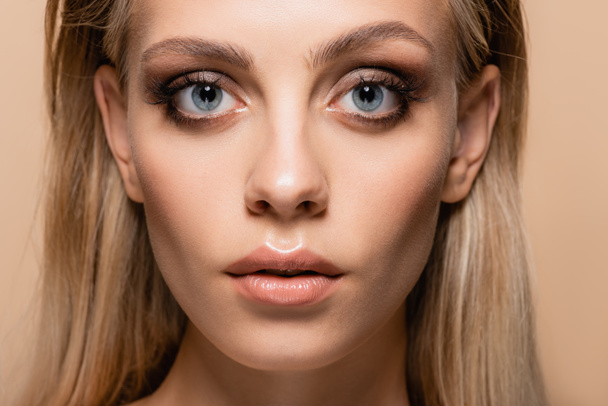 portrait of blonde woman with grey eyes and makeup isolated on beige - Photo, Image