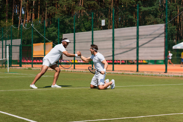 Emozionati tennisti multietnici che si stringono la mano sul campo  - Foto, immagini