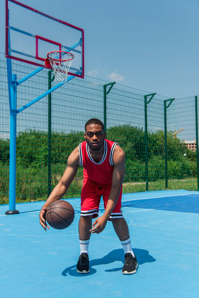 African american man playing basketball and looking at camera - Valokuva, kuva