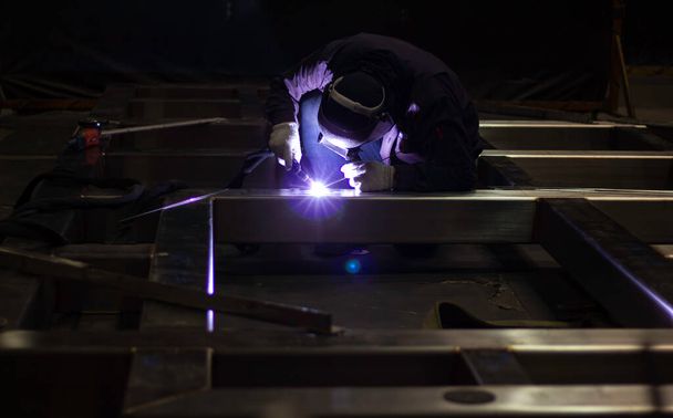 Metallarbeiter arbeiten mit Handarbeit, qualifizierte Schweißer, Fabrikarbeiter, die OT machen. Schweißer schweißt den Stahl im Werk. - Foto, Bild