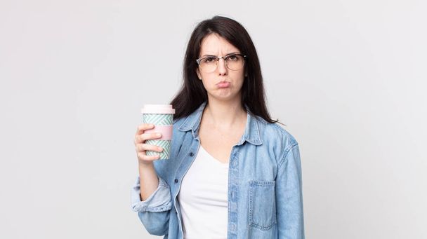 pretty woman feeling sad and whiney with an unhappy look and crying and holding a take away coffee - Fotoğraf, Görsel