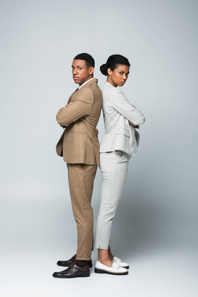 full length of african american business people standing back to back with crossed arms on grey, gender equality concept - Fotografie, Obrázek