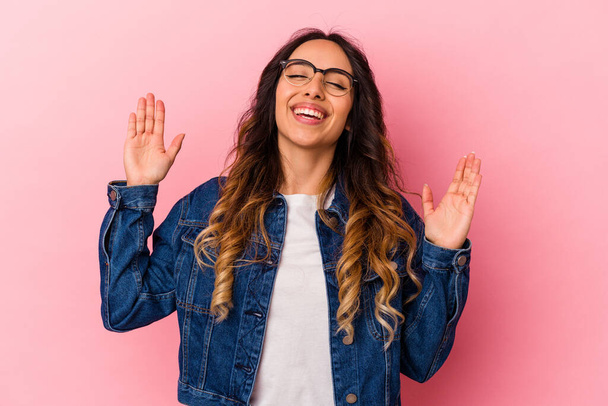 Young mexican woman isolated on pink background joyful laughing a lot. Happiness concept. - Photo, Image