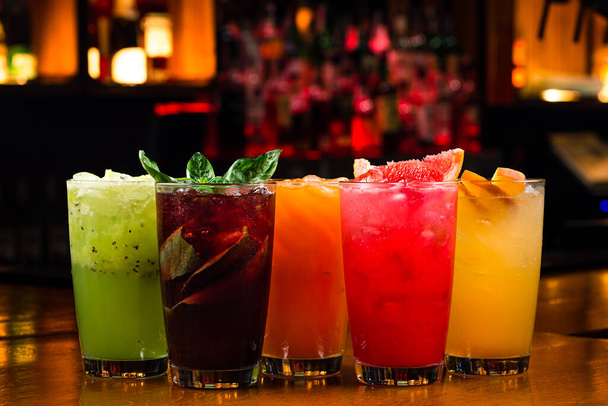 a set of summer multi-colored lemonades with cherry, basil, kiwi, sea buckthorn, raspberry and peach. Red, yellow, green and orange cocktail - Φωτογραφία, εικόνα