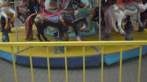 Jazda na karuzeli z końmi w parku rozrywki, popularna karuzela w parku atrakcji dla dzieci - Materiał filmowy, wideo