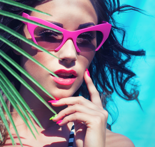 Woman wearing sunglasses by the swimming pool - Фото, зображення