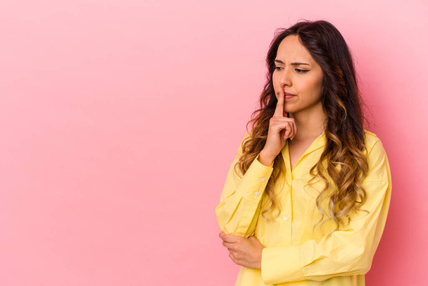 Young mexican woman isolated on pink background looking sideways with doubtful and skeptical expression. - Fotoğraf, Görsel