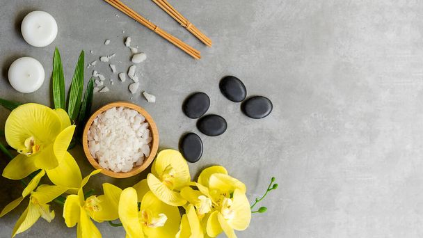 Thai Spa.  Hot stones setting for massage treatment and relax with yellow orchid on blackboard.  Lifestyle Healthy Concept,  copy space for banner, top view - Foto, imagen