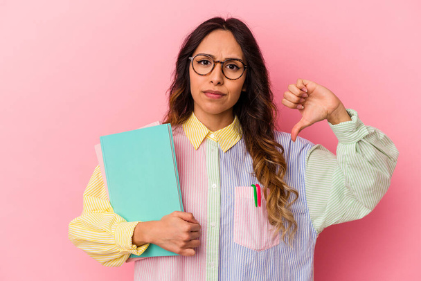 Young student mexican woman isolated on pink background showing a dislike gesture, thumbs down. Disagreement concept. - Foto, imagen