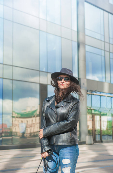 Красива молода щаслива жінка на дзеркальній стіні міського будівельного фону з порожнім простором для вашого дизайну
 - Фото, зображення