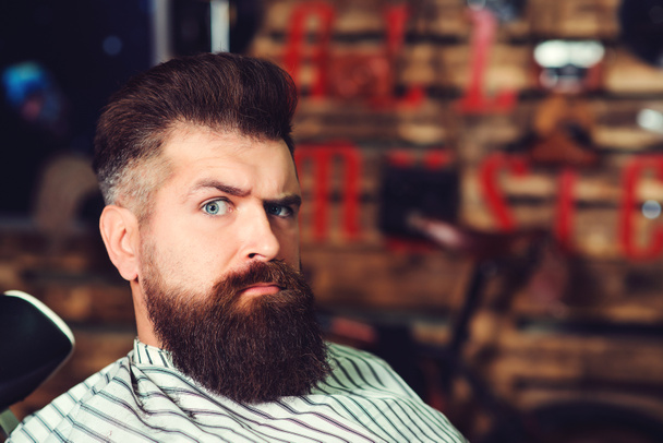Bearded man at barber shop. Men hairstyle, beard and mustache. Fashion and male beauty. Brutal serious young bearded man. Barbershop, lifestyle and people concept. - Photo, Image