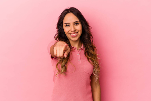 Jeune femme mexicaine isolée sur fond rose pointant vers l'avant avec les doigts. - Photo, image