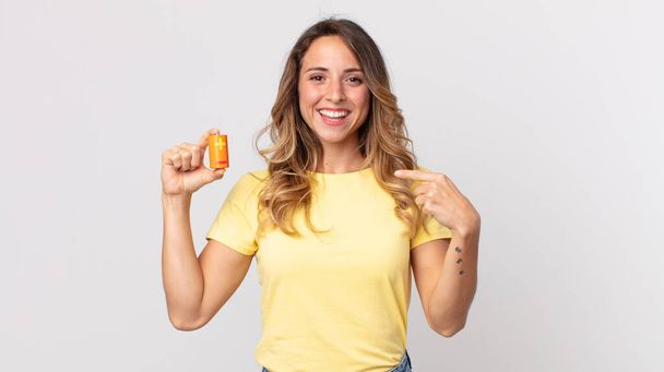 pretty thin woman feeling happy and pointing to self with an excited and holding batteries - Photo, Image