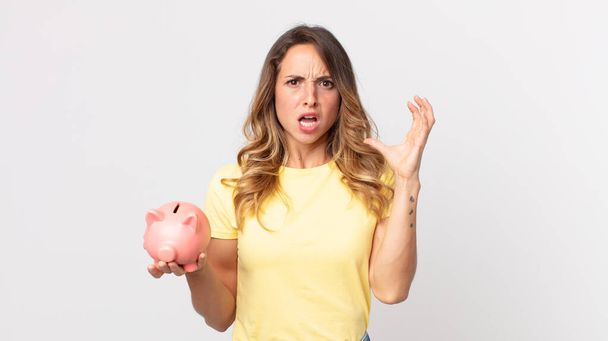 pretty thin woman screaming with hands up in the air and holding a piggybank - Photo, Image
