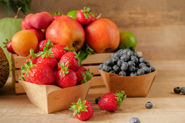 新鮮な果物だ。健康食品。混合果物、アプリコット、桃。ブルーベリーだ。古い木製のテーブルの上に様々な果物。有機健康的な各種果物。テキストの場所 - 写真・画像