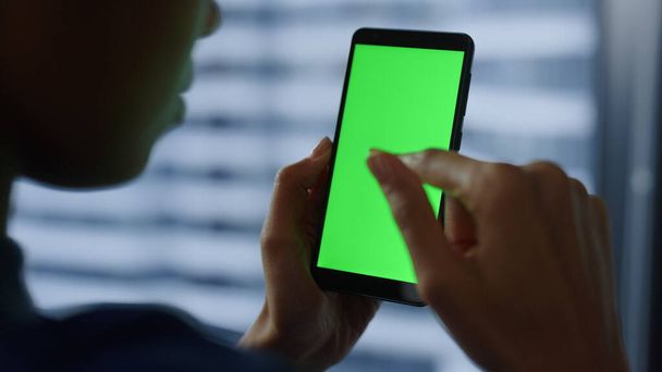 携帯電話を緑の画面で使うビジネスマン。女が携帯電話でチャット  - 写真・画像