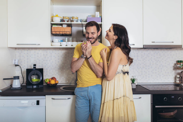 Pregnant woman with husband in the kitchen having fun. - 写真・画像