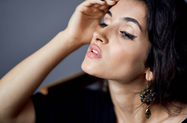 pretty woman with loose hair earrings posing close-up model - Foto, Imagen