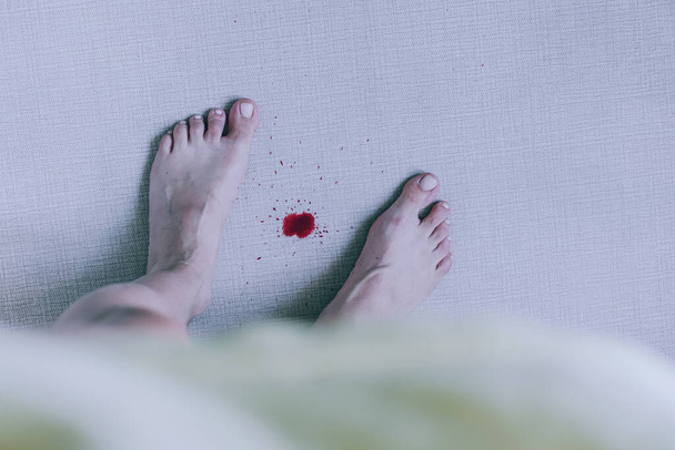 Des taches de sang menstruel sur le tapis. Hygiène féminine. concept de nettoyage. vue de dessus. Photo de haute qualité - Photo, image