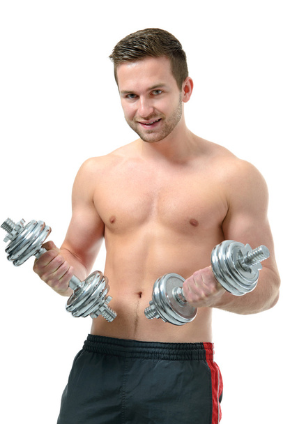 Athletic young  man doing exercises with dumbbells - Foto, Bild