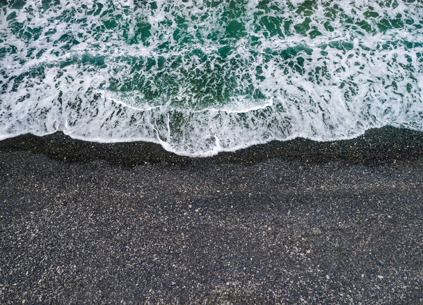Burzliwa pogoda, fale morskie rozbijające się na brzegu z wulkanicznym czarnym piaskiem, tło z przestrzenią do kopiowania - Zdjęcie, obraz
