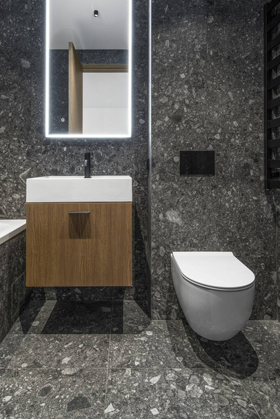Modern minimalist banyo koyu iç tasarımı koyu taş fayanslar ve ahşap mobilyalar. - Fotoğraf, Görsel
