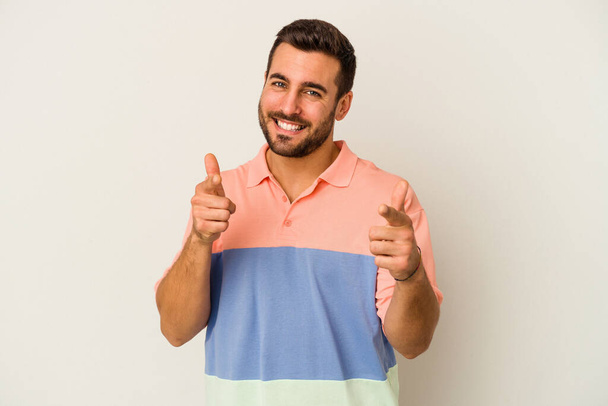 Young caucasian man isolated on white background cheerful smiles pointing to front. - Фото, изображение