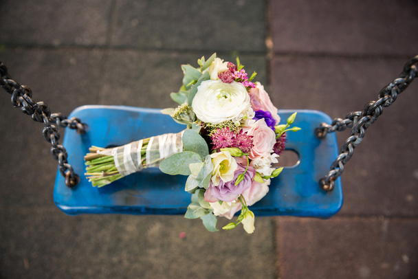 Bouquet da sposa su altalena blu
 - Foto, immagini