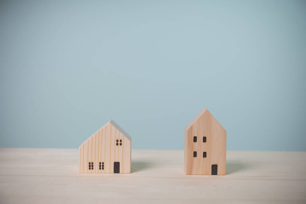 Mini dřevěný dům dva model na starém dřevěném stole. Výnosy z investic do nemovitostí za účelem zisku do budoucna. Pojetí pojistných, úvěrových, finančních a bankovních investic. - Fotografie, Obrázek