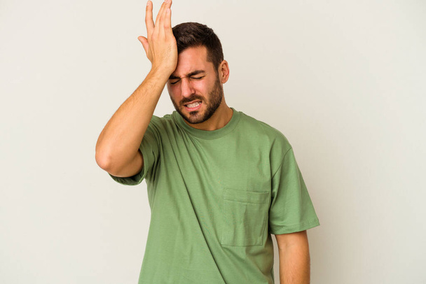Young caucasian man isolated on white background forgetting something, slapping forehead with palm and closing eyes. - Photo, Image