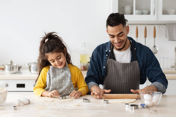 Pozitivní arabské rodiny táta a dcera pečení cookies v kuchyni spolu - Fotografie, Obrázek