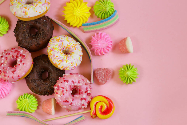 rosquillas y mermelada de caramelo dulce sobre fondo rosa - Foto, imagen