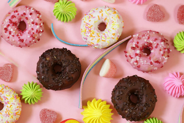 donitseja ja makeaa karkkia marmeladi vaaleanpunainen tausta - Valokuva, kuva