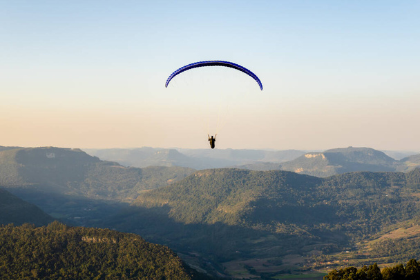 Widok z paralotni w górach Ninho das guias w Nova Petrpolis z ludźmi obserwującymi i nagrywającymi moment startu. Miejsce wykorzystywane do lotów panoramicznych z niesamowitym naturalnym pięknem - Zdjęcie, obraz
